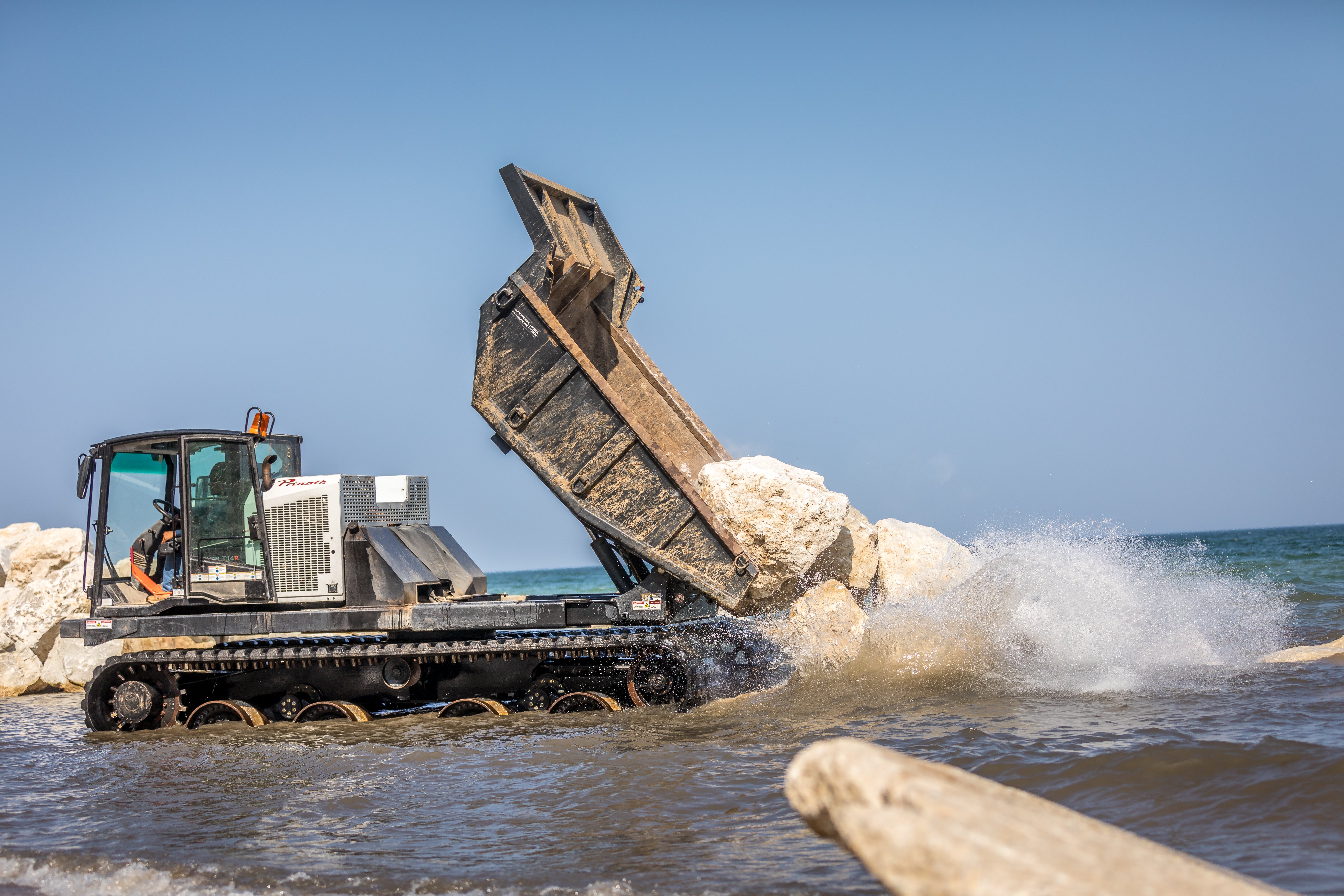 Boulder placement easier than ever with the T14R Homeowners along Lake Michigan had a necessity to safeguard their properties from excessive erosion. To address this issue, they employed a boulder erosion barrier as a solution.